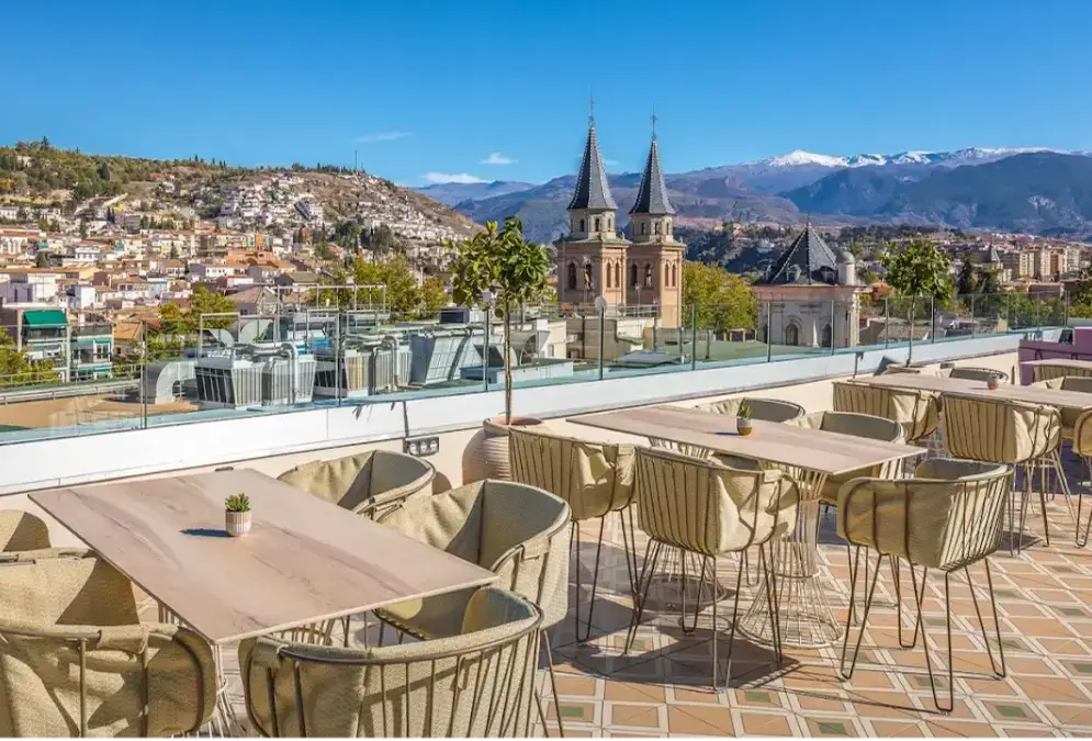 Rooftop terrace of B Heaven Granada bar with panoramic view of the Alhambra and Sierra Nevada at dusk
