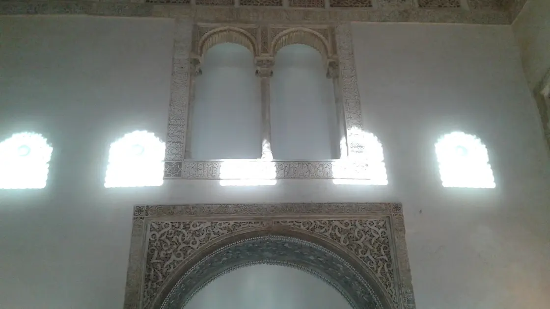 Interior of the Cuarto Real de Santo Domingo qubba in Granada, showing the muqarnas arch and blue-green glazed tile dado, 13th-century Nasrid architecture
